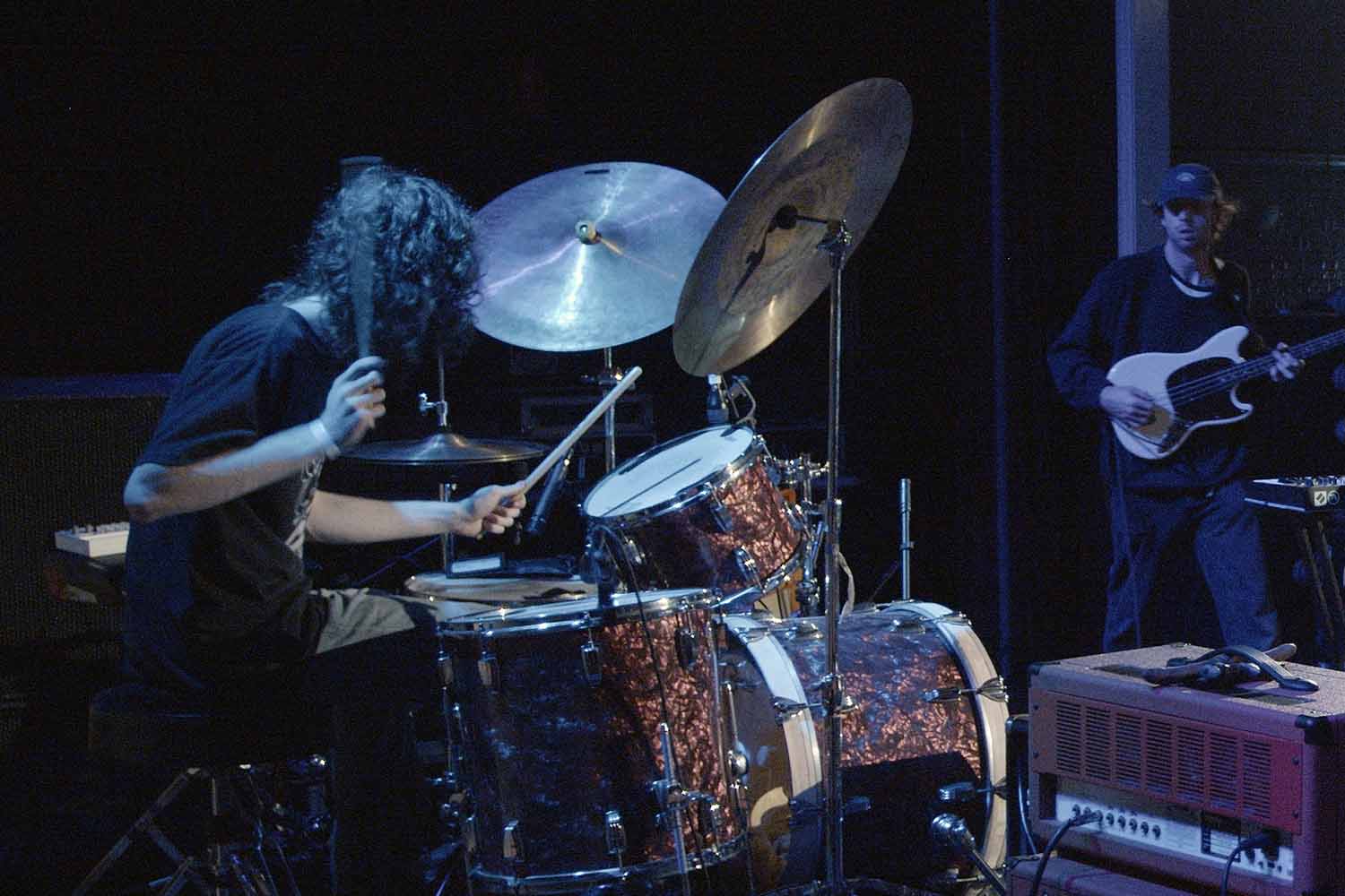 Alako Myles, producer, singer and drummer of Liminal performing drums live at a music festival